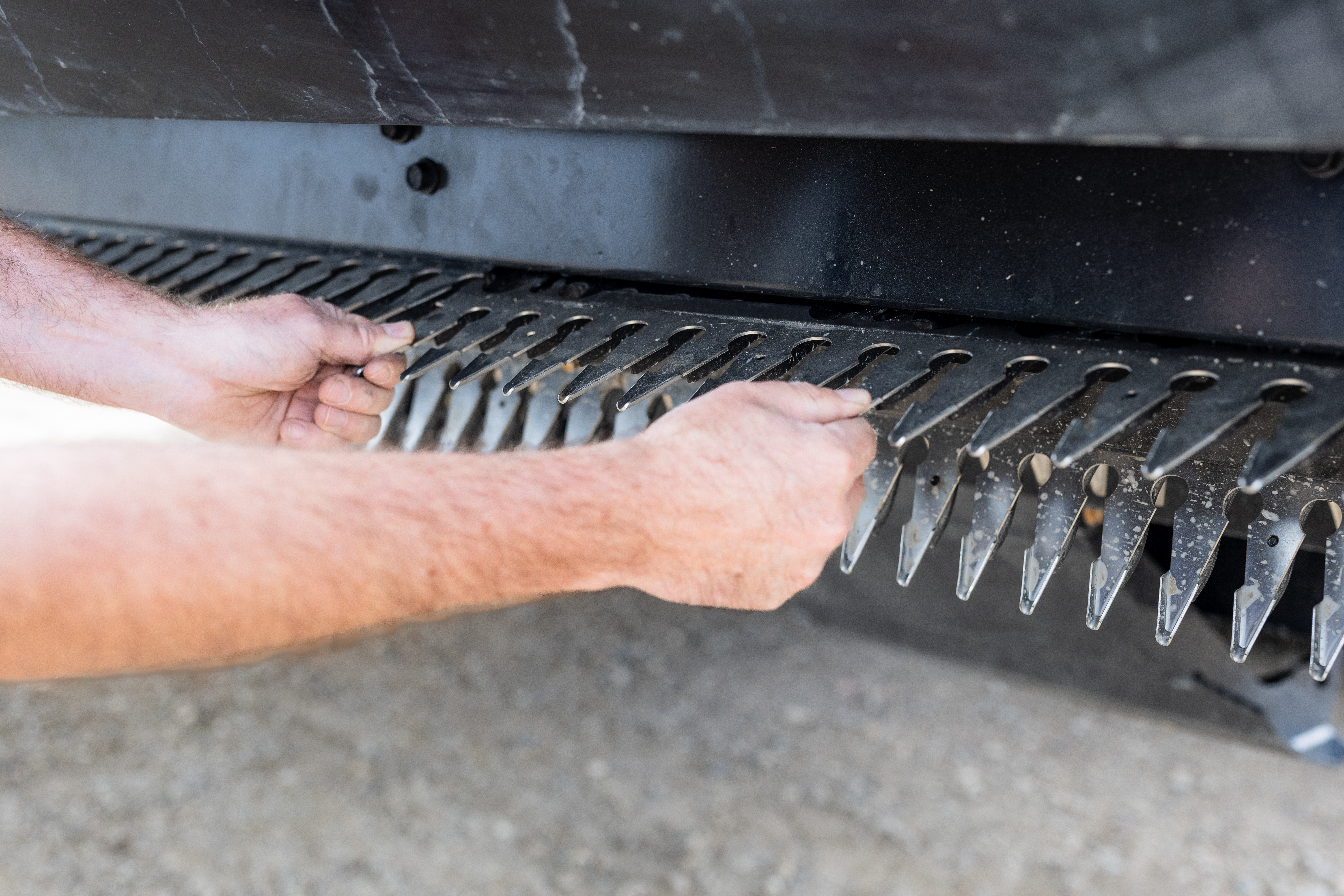 Hands replacing a finger section on the Raptor header