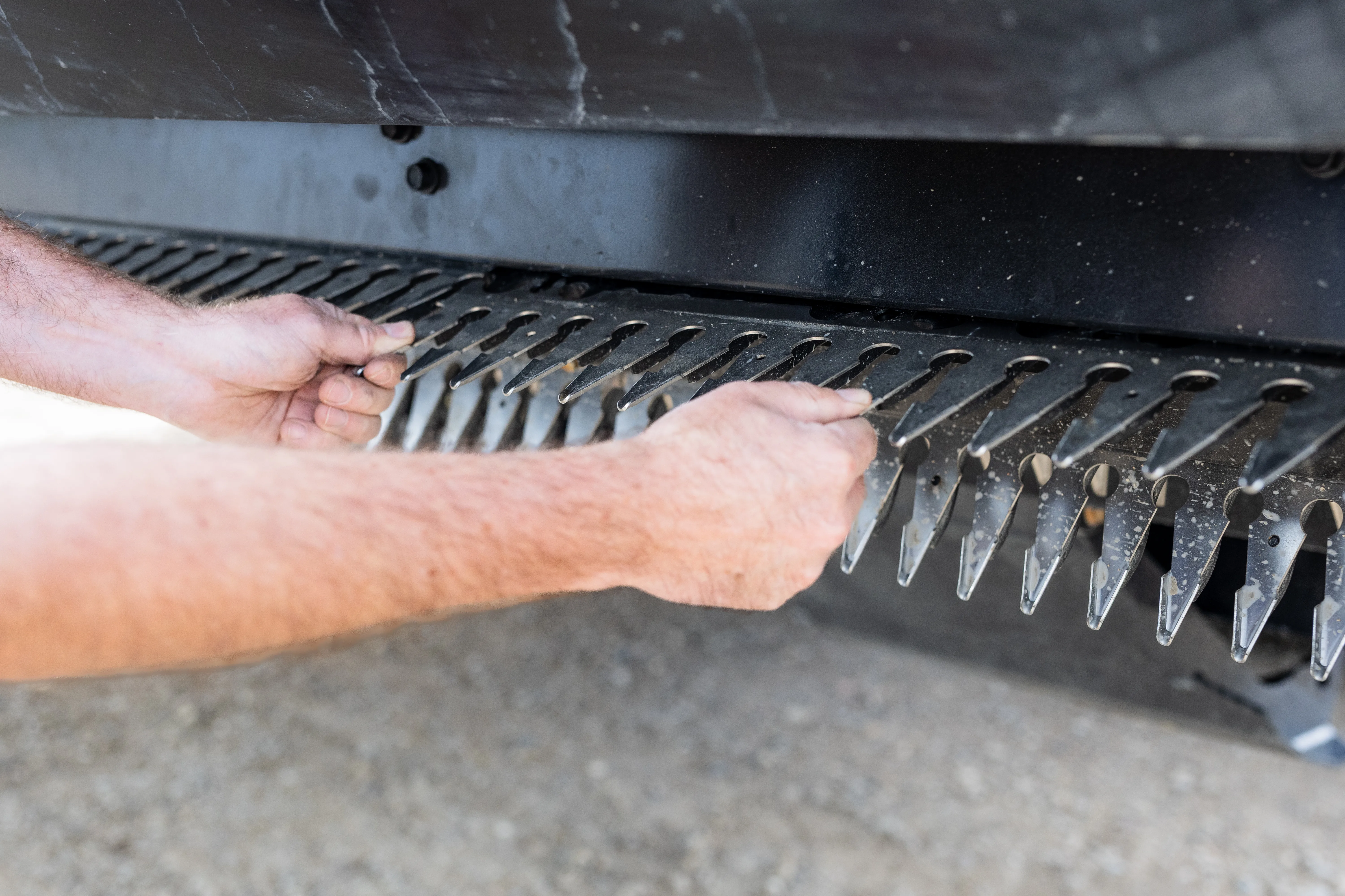 Hands replacing a finger section on the Raptor header